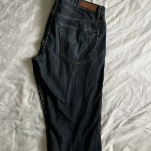 Mörkblå jeans från Hampton Republic - Snygga mörkblå jeans från Hampton Republic i klassisk femficksmodell. Jeansen har raka ben och tydliga kontrastsömmar. Perfekta till sneakers eller boots och passar dig som gillar en tidlös stil.
