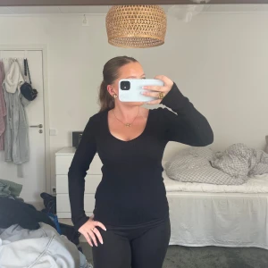 Svart ribbad långärmad tröja - Svart långärmad tröja med v-ringning och ribbad struktur. Sitter tajt och har en klassisk, enkel stil som funkar till det mesta. Säljer tröjan pågrund av att jag inte använder den. Den är använd ett fåtal gånger 💕💕