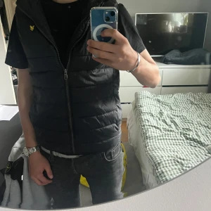 Svart Lyle and Scott väst - Säljer nu denna svarta riktigt snygga lyle and scott väst. Skick är 10/10, använd 4-5 gånger. Den är köpt från kidsbrandstore för 799. Storleken är 12/13 år men är lite stor i storleken så passar dig mellan 155-165cm. Modellen är 170. Hör av er om någon helst fundering osv. Priset är inte hugget i sten⚜️