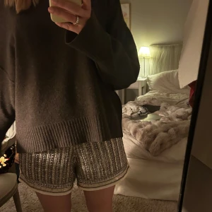 Glittriga shorts med paljetter - Säljer ett par glittriga shorts med silvriga paljetter och vita kanter. Shortsen har en loose passform och är perfekta för att sticka ut. 💗💗