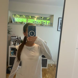 Vit långärmad topp med volangdetaljer - Säljer en vit långärmad topp med rund hals och volangdetaljer på axlarna. Tillverkad i mjuk bomull, perfekt för en enkel och stilren look. Passar dig som gillar diskreta men fina detaljer. Toppen är från Odd Molly