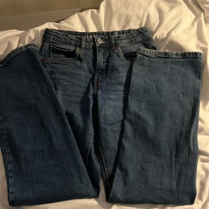 Blå jeansbyxor från LAB Industries - Säljer ett par klassiska blå jeansbyxor från LAB Industries. Byxorna har normal passform med raka ben och femficksdesign. Perfekta till vardags och enkla att matcha med olika toppar. Stängs med dragkedja och knapp.