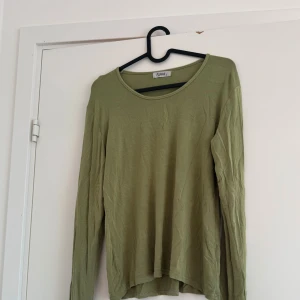 Olivgrön långärmad tröja  - Superfin och skön olivgrön långärmad tröja från Repeat. Rund halsringning och är tillverkad i ett mjukt, tunt material. Strl L men sitter rätt figurnära så funkar även för mindre storlekar om man vill ha den oversized . Säljer då den tyvärr inte kommer till användning <33