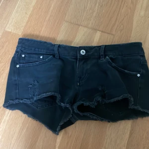 Svarta jeansshorts från Mango Jeans - Svarta jeansshorts från Mango Jeans med låg midja och lite slitningar. Klassisk femficksmodell med knapp och dragkedja. Perfekta för varma dagar och enkel att matcha med olika toppar. Storleken motsvarar ungefär S-M. Kontakta privat för mer information! ☺️❤️