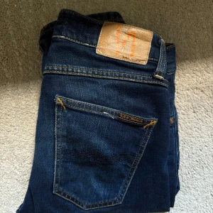 Mörkblå Nudie Jeans    - Snygga mörkblå jeans från Nudie. Modell Grim trim! Riktigt fräscha för våren och kan användas till många outfits! Original pris 1600kr Storlek 28/32