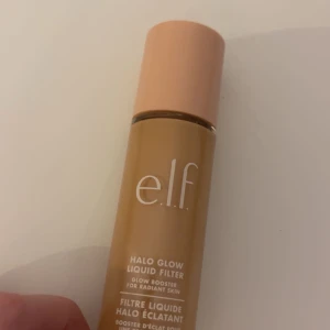 e.l.f. Halo Glow Liquid Filter Shade 2 Fair/Light - Glow booster från e.l.f. i nyansen Shade 2 Fair/Light. Ger huden en strålande finish och kan användas ensam eller under foundation. Kommer i en smidig flaska med persikofärgat lock.