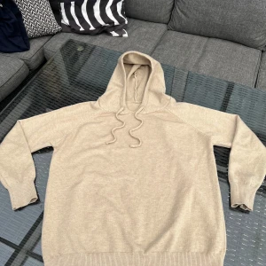 Sand merinoull hoodie - Säljer inte exakt samma tröja som på bilden men den är i samma material. Den är färgen Sand. Tröjan har en tajt passform. Perfekt för dig som gillar en enkel och stilren look. Passar till det mesta och är riktigt skön att ha på sig.