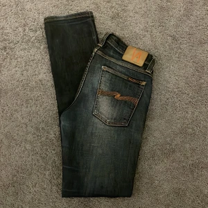 Nudie jeans - Säljer ett par mörkblå jeans från Nudie Jeans, Strlk W28 L32. Skick 10/10 nästan helt nya använda 2-3 gånger. Pris är inte satt i sten, meddela mig vid frågor eller funderingar.
