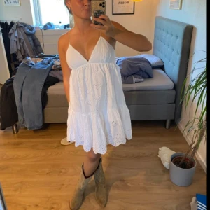 Vit Zara klänning  - Säljer en söt vit klänning med tunna axelband och v-ringning. Klänningen har broderade detaljer. 💕Perfekt för varma dagar! En Zara känning som inte säljs längre. (Inte mina bilder)