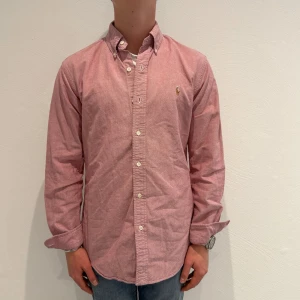 Rosa ralph lauren skjorta - Rosa Ralph lauren skjorta || Storlek S (Custom Fit) || Skjortan är i mycket bra skick || Mitt pris 599kr || modellen på bilden är 170cm och väger 63kg || Tveka inte på att höra av dig vid frågor eller funderingar 