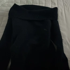 Mörkblå stickad tröja från Gina Tricot - Mysig svart stickad tröja från Gina Tricot med bred krage som kan vikas ner. Aldrig använd då den var för liten för mig. Långärmad modell i mjukt material. Nypris: 250kr