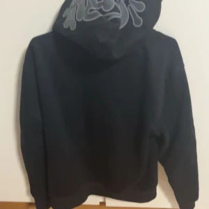Svart Syna world hoodie - Säljer en svart Syna world hoodie. Jättebevkäm hoodie och ger en oslagbar känsla. Perfekt inför vintern och hösten. Jag har tyvärr inget kvitto men jag har påsen som ett bevis på att den är äkta.                                                                                 Pris går att diskutera