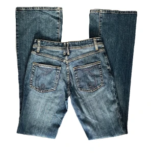 Jeans - Snygga blå jeans i vintage stil med broderade detaljer på bakfickorna, bootcut. Passformen är mer normal än high rise. 