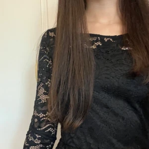 Svart spetsklänning/ black lace dress - Säljer en elegant svart spetsklänning med trekvartsärmade detaljer. Klänningen har en vacker spetsdesign och en rund halsringning. Perfekt för speciella tillfällen. I jättebra skick och storleken är 146/152