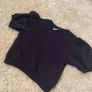 Mörkblå tröja från Gina tricot  - Säljer en snygg mörkblå tröja från Gina tricot . Tröjan har puffiga korta ärmar och en rund halsringning. Perfekt för en stilren look! Ganska kort men inte för. Pris kan diskuteras. Skriv privat för fler bilder.