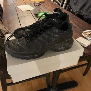 Svarta Nike TN helsvarta  - Säljer mina TNs som jag köpte 2023 i Prag på footlocker för ca 2400, har inte använt dem senaste året och är inte längre min stil. Skick är som bilderna, enligt mig ett fint helhetsintryck! Har bild på originalbox och har bild på kontoutdrag från footlocker från att jag köpte den, självklart äkta. Prutare undanbedes. Fraktas helst men kan mötas. 