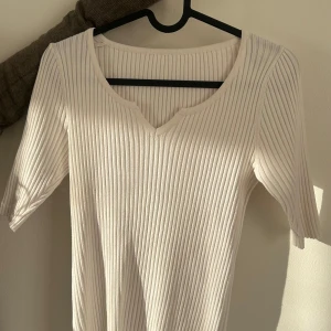 Vit ribbad topp - Säljer en väldigt fin topp med en v-ringning. Perfekt för en enkel och elegant look. Passar till både svarta och blåa jeans. Är inte genomskinlig. Säljer då den tyvärr inte kommer till användning längre! Pris kan diskuteras❤️OBS! Den har ingen storlek men passar mig som brukar bära S!