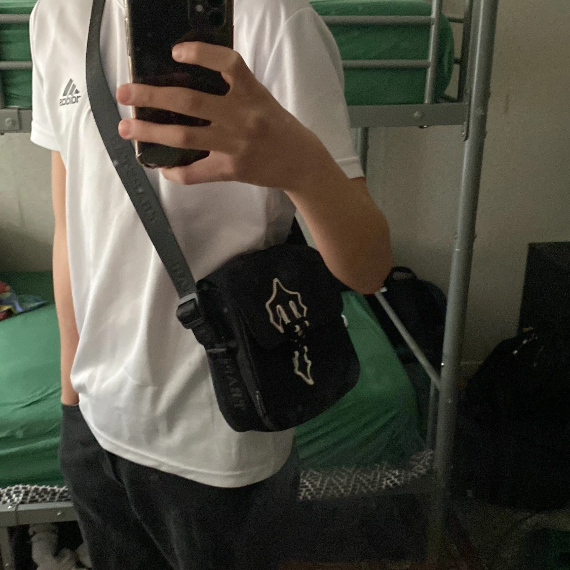 Svart axelväska med dekorativt emblem - 4