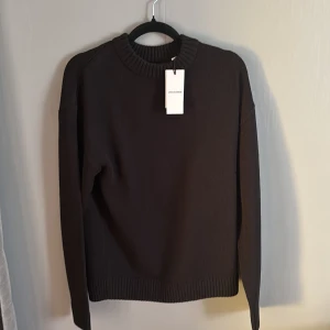 Svart stickad tröja från jack&jones - Säljer en stilren svart stickad tröja från  jack&jones. Tröjan har en klassisk rund halsringning och långa ärmar. Perfekt för kyligare dagar och enkel att matcha med olika outfits.