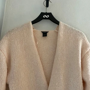 Beige stickad kofta från Lindex - Mysig rosa stickad kofta från Lindex. Populär speciellt nu till våren. Storlek xs-s. Endast använd ett fåtal gånger och i bra skick. Färgen är ljusrosa men syns inte så bra på bilderna. Inköpspris 400. 