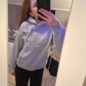 Ljusblå hoodie från Lindex - Säljer en ljusblå hoodie från Lindex i storlek 146/152. Den har en klassisk känguruficka och en bekväm huva. Passar bra till både jeans och mjukisbyxor.