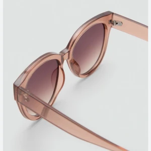 Rosa solglasögon med rundad form - Snygga rosa solglasögon med rundad form och transparent båge. Perfekta för soliga dagar med stil. De har en lätt tonad lins som ger ett coolt intryck.