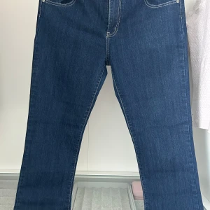 Blå jeans från Memories - Snygga blå jeans från Memories med kontrasterande rosa detaljer på insidan av midjan. Klassisk femficksdesign och raka ben för en tidlös look. Perfekta för en avslappnad stil.