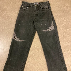 Svarta jeans med Orlando Magic-tryck - Säljer ett par sällsynsta svarta jeans från UNK Denim med Orlando Magic-tryck (dessa säljs för 900-1000kr på ebay). Jeansen har en baggy passform och är tillverkade i 100% bomull. Använda med slitage vid ändarna. 