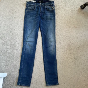 Blå Replay jeans skinny fit - Säljer ett par snygga blå jeans från Replay modell anbass. Jeansen har klassisk femficksdesign och en fin tvätt. De är tillverkade i stretchigt denim för extra komfort och har låg midja.