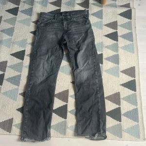 Replay svarta jeans straight fit - Snygga svarta jeans från Replay med klassisk femficksdesign och raka ben. Jeansen har en cool tvättad look och tydliga Replay-detaljer vid fickan. Passar dig som gillar en enkel och stilren vibe. Materialet är slitstarkt jeans och midjan är normal.