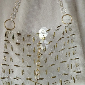 Transparent axelväska från Cult Gaia - Unik transparent axelväska från Cult Gaia med cirkelformade akryl detaljer och guldfärgade länkar. Väskan har en kedja som axelrem och coolt geometriskt mönster. Perfekt för dig som gillar statement-accessoarer och vill sticka ut. Finns skavanker där guldplateringen har släppt tyvärr men annars så himla snygg 