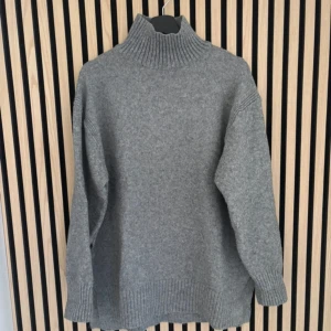 Grå polotröja från hm - Mysig grå polotröja från hm i stickad ullmix. Tröjan har en hög, ribbad polokrage och långa ärmar med ribbade muddar. Passformen är loose och perfekt för lager-på-lager under kyliga dagar nu till hösten🍂💞.