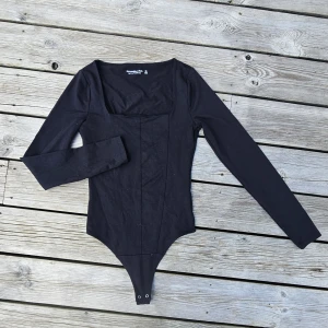 Långärmad body  - En långärmad svart body från Abercrombie & Fitch i storlek XS. Starkt material, sällan använd, jätte fint skick! 
