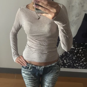 Beige långärmad topp i bomull - Säljer en supermjuk och tunn beige långärmad topp i bomull. Modellen är tight och har en enkel, stilren design med rund halsringning. Perfekt att styla med jeans eller kjol för en clean look.