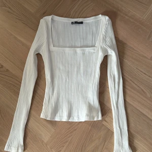 Vit ribbad långärmad topp från Zara - Säljer en vit långärmad topp från Zara med fyrkantig urringning och ribbad struktur. Toppen är figurnära
