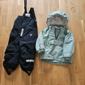 Mint grön vinterjacka Polarn O. Pyret 92 , skidbyxor vinter 86 - Snygg mintgrön vinterjacka från Polarn O. Pyret med huva och mysigt fleecefoder. Jackan har reflexdetaljer, dragkedja framtill och praktisk ficka med knappar. Perfekt för den lilla kroppen och slitstarka för förskolebus. Använda av endast ett barn.  Se  exempel priser för varor på hemsidan. Mitt pris: 600kr för jackan och 450 för byxorna. 