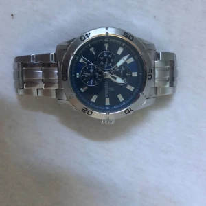 Festina herrklocka med blå urtavla - Stilren herrklocka från Festina med robust länkarmband i silverfärgat stål och en snygg blå urtavla. Klockan har kronograf, datumvisning och tydliga indexmarkeringar. Perfekt accessoar för dig som gillar sportig och klassisk stil.