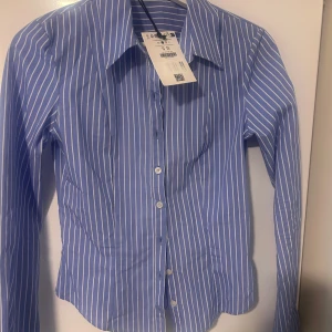 Blåvit randig skjorta från Bershka - Snygg blå skjorta med vita ränder från Bershka. Figursydd midja och vida ärmar, aldrig använd 💙🤍