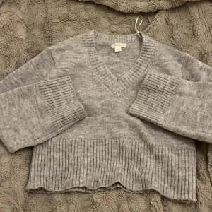 Grå ribbstickad tröja Gina Tricot - Mysig grå stickad tröja från Gina Tricot med bred ribbstickad kant nertill och på ärmsluten. Ni får säga till om ni vill veta hur den ser ut på💗