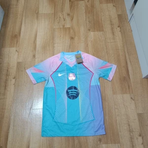 Barcelona tröja  - Barcelona fotbollströja från Nike med Dri-Fit material. Tröjan har coola pastellfärger i blått, rosa och lila med grafiska linjer och Spotify-logga på bröstet. Priset kan diskuteras 