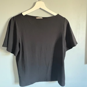 Vit kortärmad topp - Säljer en stilren vit & svart T-shirt med korta pösiga ärmar. Lite lyxigare material än en vanlig T-shirt, aldrig använda +man får med båda. Strl xs men S ev M funkar lika bra💕