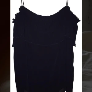 Svart topp - Snygg svart topp med volangdetaljer och smala axelband. Från Massimo Dutti, skit snygg till sommaren och till festligare tillfällen. Färgen är mörkblå.