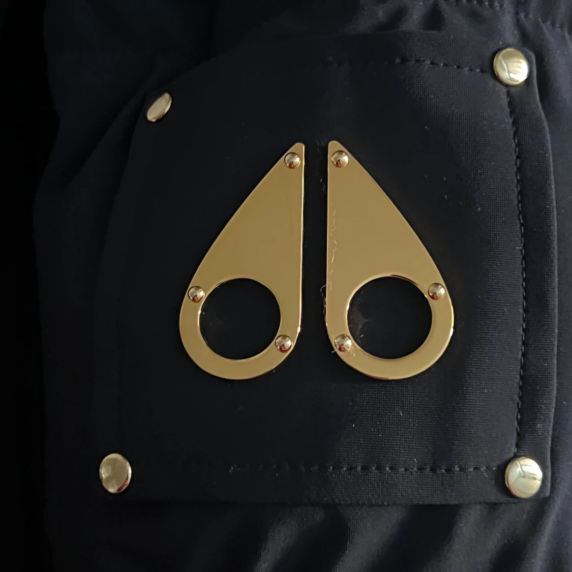 Svart pufferjacka med gulddetaljer