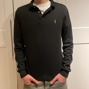  långärmad piké från Ralph Lauren - Säljer en stilren svart långärmad pikétröja från Ralph Lauren. Storlek M men passar XS/S. Bra skick och knappt använd. Nypris ca 1500kr