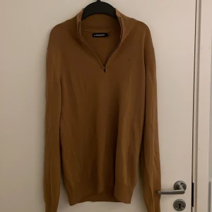 Stilren brun J.Lindeberg Zip up  - Säljer en stilren brun tröja från J.Lindeberg i storlek S. Tröjan har en praktisk dragkedja vid halsen och långa ärmar. Perfekt för en avslappnad men ändå snygg look. Sitter perfekt för dig med väl tonad kropp och för din vardagliga look. Nypris 1800kr, 9/10 skick.