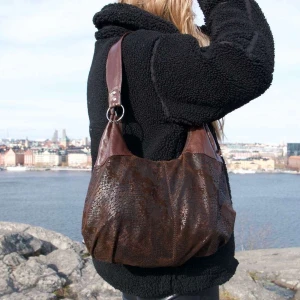 Brun axelväska  - Snygg brun axelväska. Väskan har en praktisk dragkedja och rymligt huvudfack. 