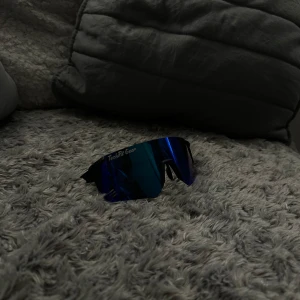 Svarta sportiga solglasögon med blå spegelglas från TechFit Gear - Snygga och sportiga solglasögon från TechFit Gear med svarta bågar och blå spegelglas. Perfekta för en aktiv livsstil och skyddar mot solen med stil.