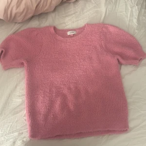 Rosa stickad tröja från Vero Moda - Säljer en söt rosa stickad tröja från Vero Moda. Tröjan har korta ärmar och en mjuk, fluffig textur som ger en mysig känsla. Perfekt för en avslappnad stil. 💖