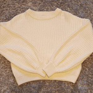 Beige stickad tröja från NA-KD - Säljer en mysig beige stickad tröja från NA-KD. Tröjan har en ribbad struktur och långa ärmar, perfekt för kyliga dagar. Den är i storlek XXS och passar utmärkt för en stilren och bekväm look.