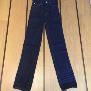 Mörkblå jeans från Cheap Monday - Helt nya jeans från Cheap Monday. ”Sleezie high”mörkblå stretchjeans W25L30. Väldigt små i storleken. Midja:29cm midjehöjd:26cm, höft:34,5cm,lår:20cm, vad:16cm,ben öppning:16cm,innerben:76,5cm.Dubbla måtten för omkrets. 2%elastane(stretch)